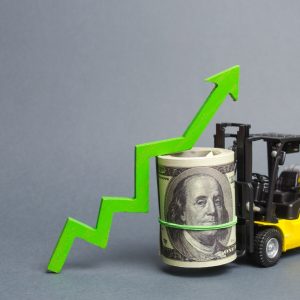 Yellow Forklift truck carries a big bundle of dollars and green up arrow